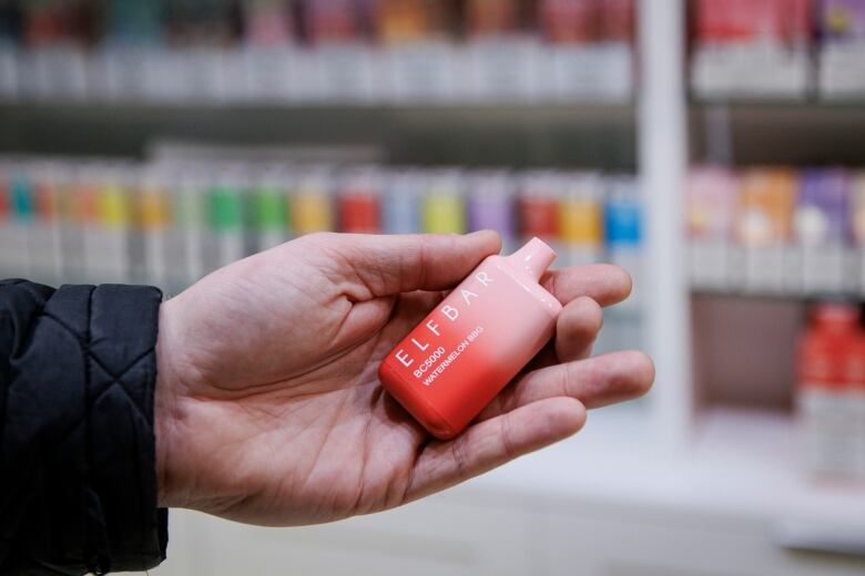 The CBCs Adam Miller holds an Elf Bar vaping device at a downtown Toronto vape shop on April 25, 2023.