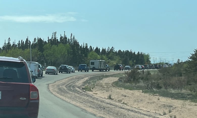 Lineup of cars on curving road.