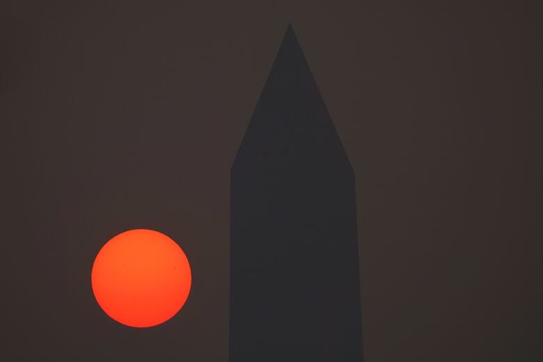 Red sun  behind monument shadow