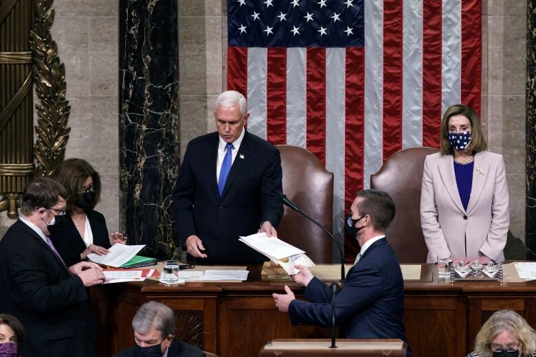 Pence on podium, hands over paper