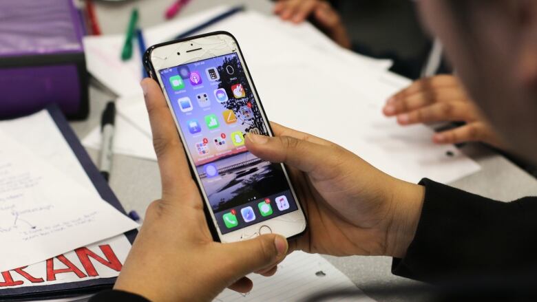 Teenagers are shown on cellphones, in closeup. 