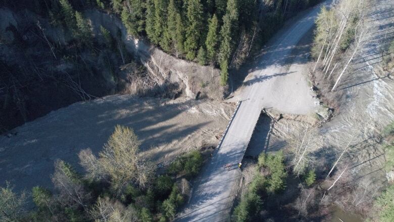 A damaged bridge over a creek.