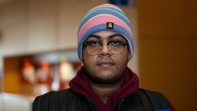 A man with hat and glasses poses for a photo.