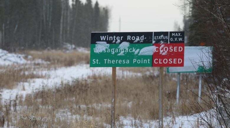 A sign, with snow sticking to it, declares the winter roads to Wasagamack and St. Theresa Point are closed.