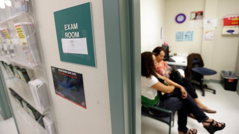 Two women wait in an exam room in this file photo.