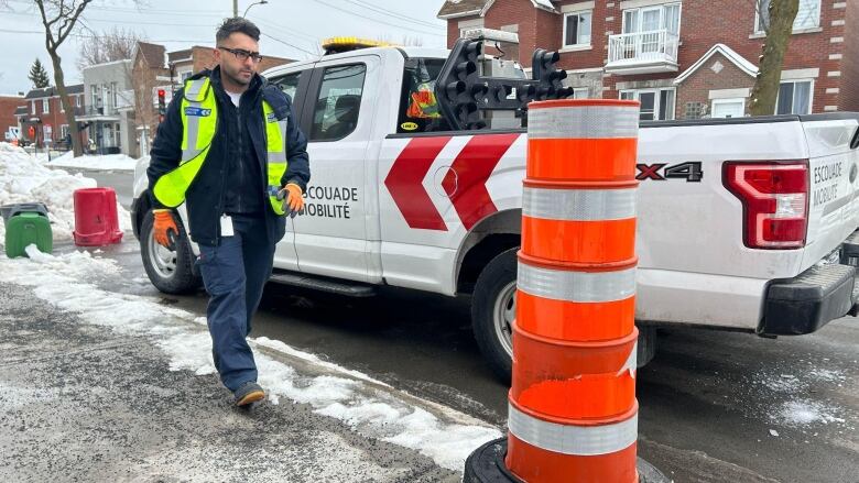 A man walks toward a cone.