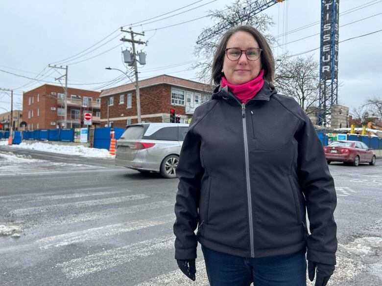 A woman stands in the street.