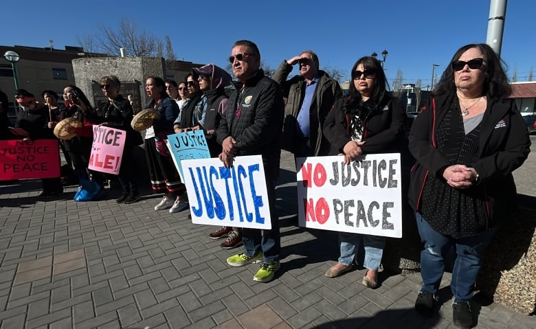 A group of people holding signs reading 