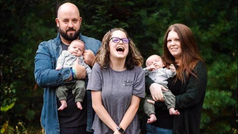 A family portrait of a man, woman, teenaged girl and two baby twin boys. 