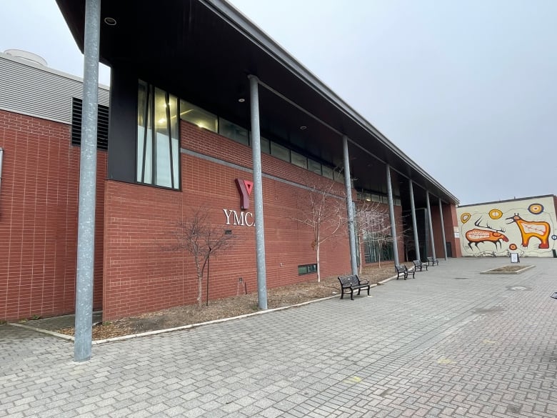 the outside of a large brick building with a colourful mural to the right.