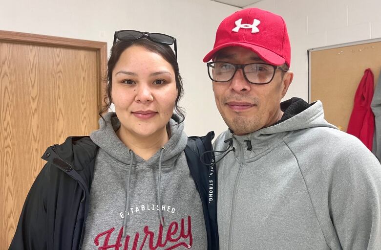 Two people posing for a camera, indoors.