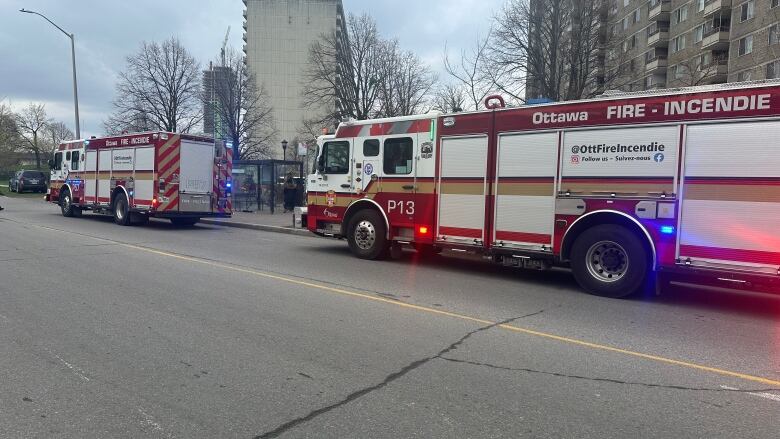 Fire trucks in front of a highrise apartment building.