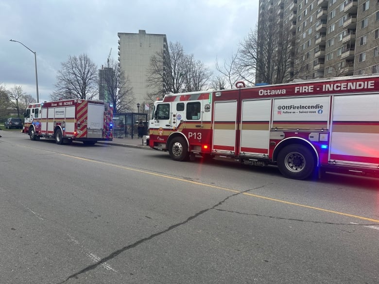 Fire trucks in front of a highrise apartment building.