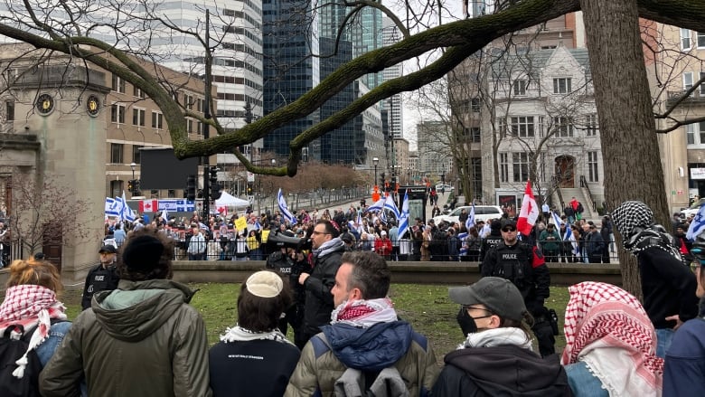 Two groups of protesters separated by police.