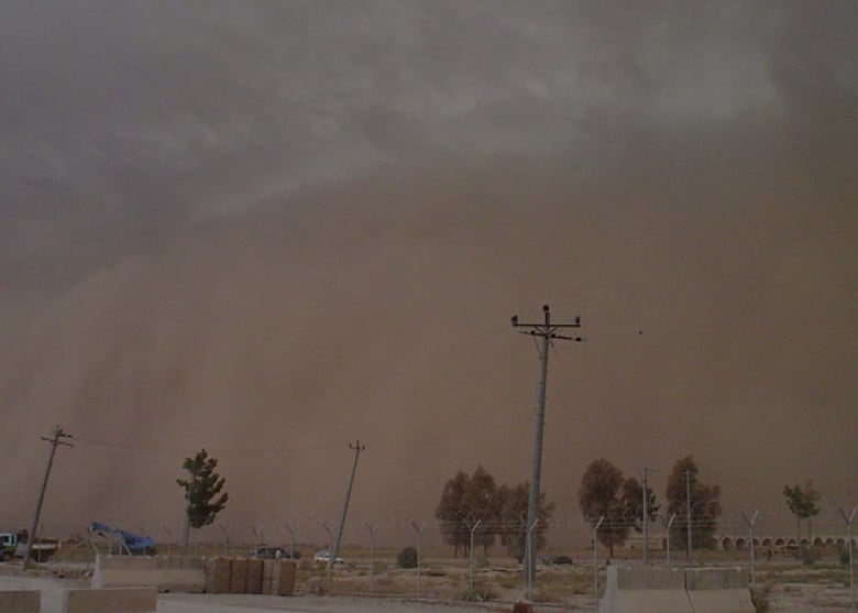 A dust cloud looks ominous as it fills half of the lower part of the sky. 