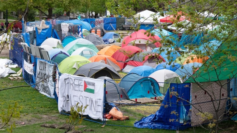 Dozens of tents surrounded by fencing. 