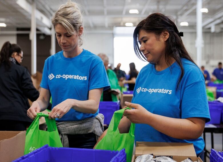 Volunteers help pack lunches during a Food Banks Canada packing drive, at the International Centre, in Mississauga, Ont., on May 15, 2024.