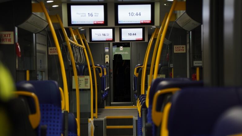 The inside of an empty train with blue seats