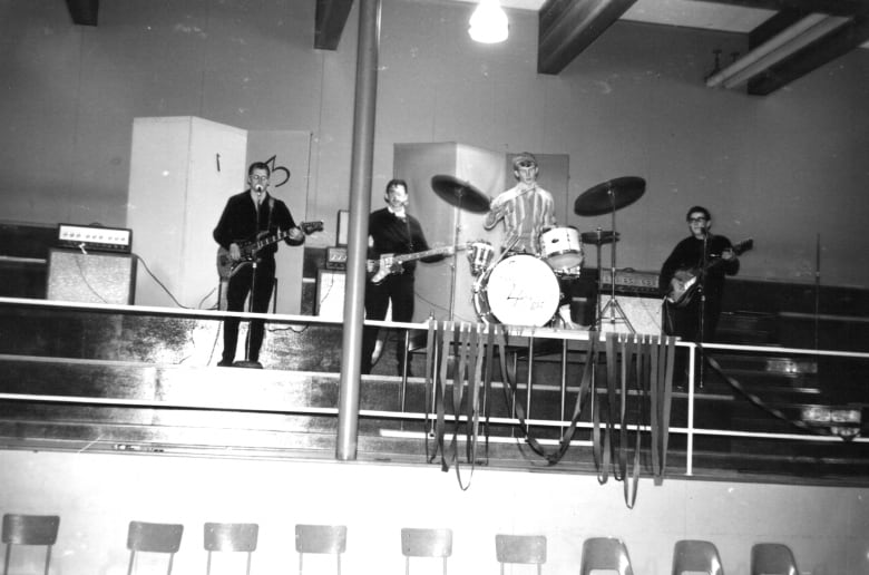 A band on a stage in a black and white photo