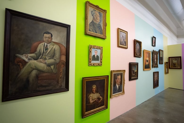 a wall of antique oil portraits