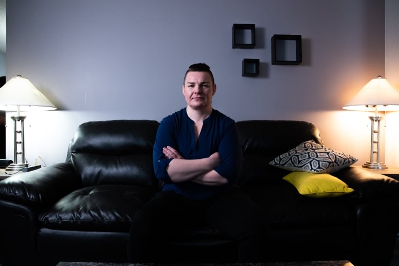 A picture of a woman with short hair sitting on a couch.