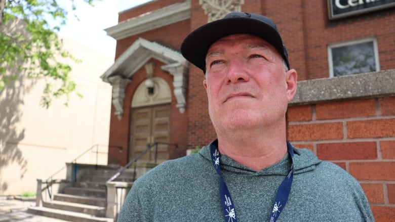 A man wearing a cap looks off into the distance.