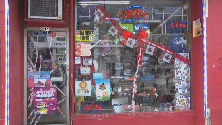 A storefront shows broken windows. 