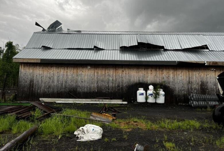 A barn with a damaged roof.