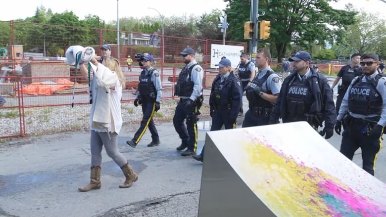 Officers walk down a city street.