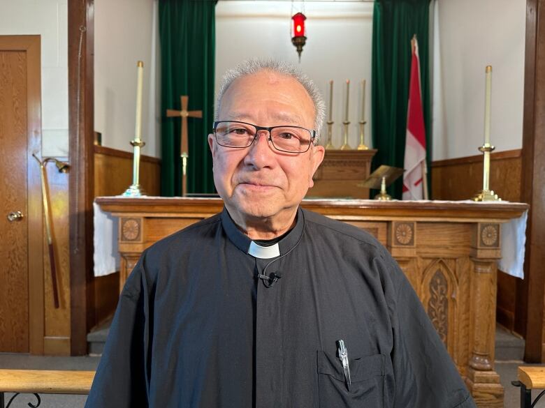 A priest stands in a church.