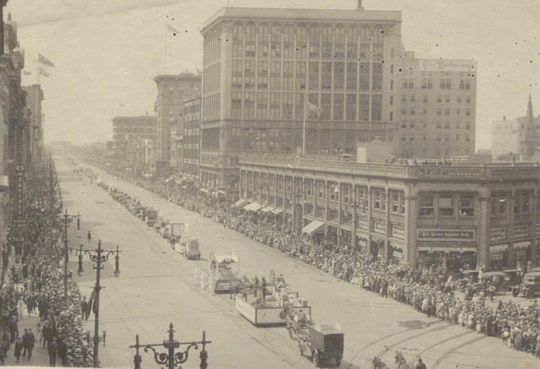 Aerial view of a parade and large crowds on a downtown street