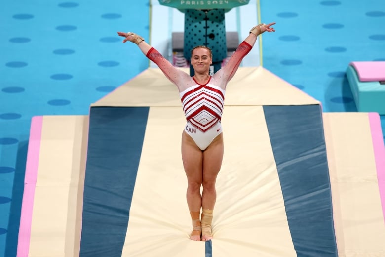 A female gymnast is seen after landing in a presentation.