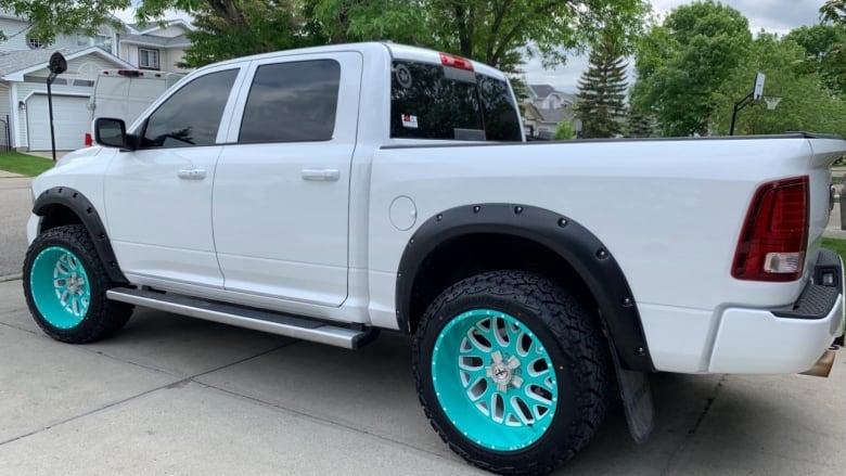 a white truck with teal rims