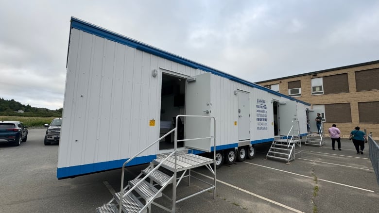 Exterior of a large trailer with a small set of stairs leading inside.