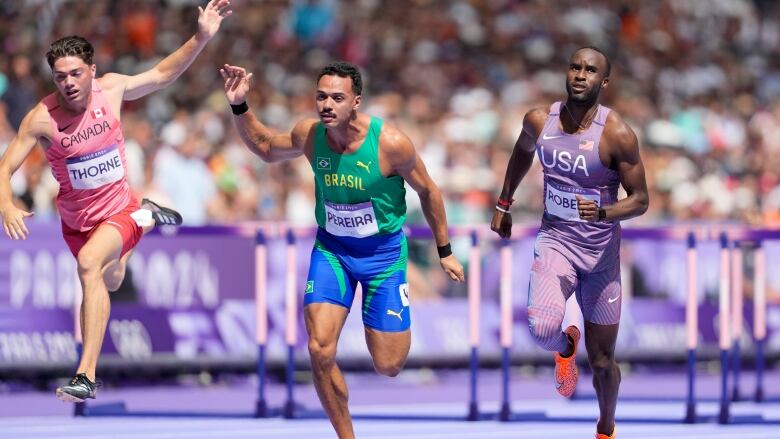 Three track athletes cross the finish line