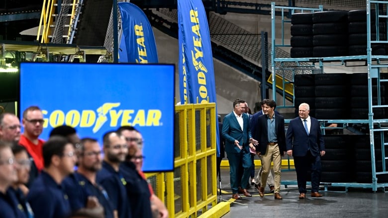 Left to right, Mark Stewart, Chief Executive Officer and President of Goodyear, centre left, Prime Minister Justin Trudeau, and Premier of Ontario Doug Ford arrive for an announcement at the Goodyear plant in Napanee, Ont., on Monday, Aug. 12, 2024. 