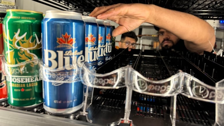 A man puts cans of beer into a cooler 