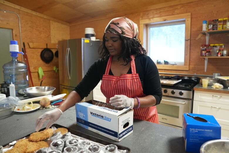 Woman prepares tray of cookies and muffins