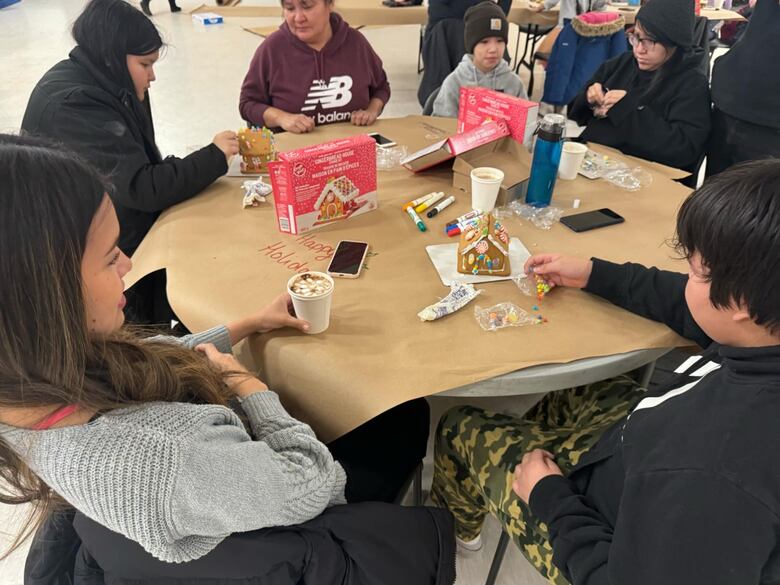 A group works on gingerbread houses.