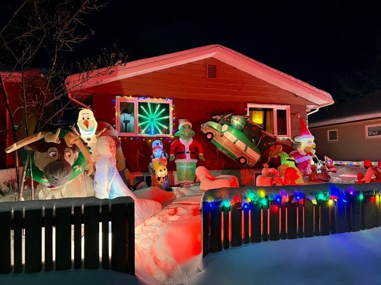 A house with blow-up Christmas decorations and lights outside 